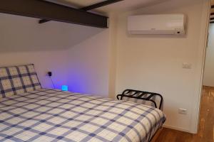 a bedroom with a bed with a checkered blanket at La casa degli ulivi in Lierna