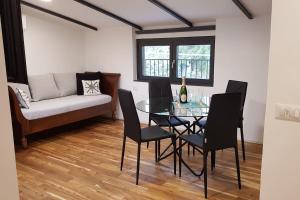 a dining room with a table and chairs and a couch at La casa degli ulivi in Lierna