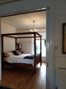 a bedroom with a canopy bed in a room at The Garden Apartment in Weymouth