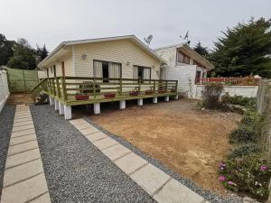 une maison avec terrasse couverte dans une cour dans l'établissement Casas Isla Negra, à El Quisco