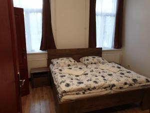 uma pequena cama num quarto com janelas em Guest House Orczy Park em Budapeste