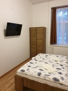 a bedroom with a bed and a flat screen tv at Guest House Orczy Park in Budapest
