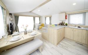 a kitchen and living room with a table and a couch at Modern mobile home premium pitch in Port Seton