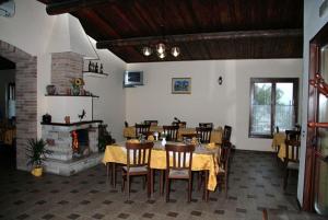 a dining room with a table and chairs and a fireplace at Agriturismo La Botte in Fragneto Monforte