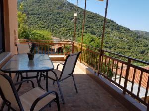a balcony with a table and chairs and a mountain at Dimitra's Garden Villa in Kallirakhi