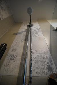 eine Dusche in einem Zimmer mit Fliesenboden in der Unterkunft Nürburgring Aparts in Welcherath