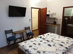 Zimmer mit einem Bett und 2 Stühlen sowie einer Küche in der Unterkunft Guest House Orczy Park in Budapest
