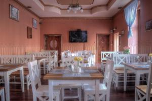 a dining room with white tables and white chairs at BedRooms Piotrkowska 64 in Łódź