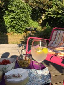 a glass of wine sitting on a table next to a chair at Chambre au calme centre ville in Caen