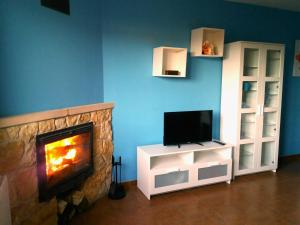 a living room with a fireplace and a tv at El Cierzo de la Mata in Mata de Quintanar