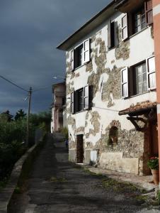 un antiguo edificio de piedra al lado de una calle en Il Viandante, en Santo Stefano di Magra