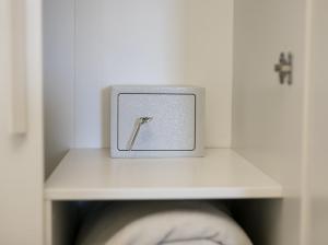a white cabinet with a door open with a metal switch at B&B La Fenice in Pompei