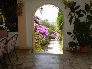 an archway leading to a garden with flowers at Apartments Nada in Sućuraj
