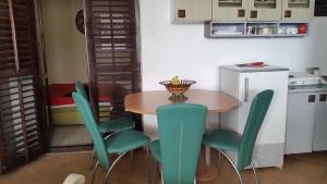a kitchen with a table and green chairs at Guesthouse Ada in Bar