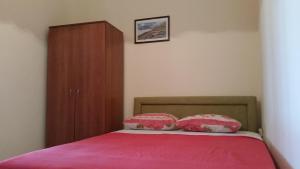 a bed with two pillows and a wooden cabinet at Guesthouse Ada in Bar