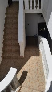 a stairway with a white stair case with a rug at Guesthouse Ada in Bar