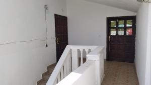 a hallway with white walls and stairs with a door at Guesthouse Ada in Bar