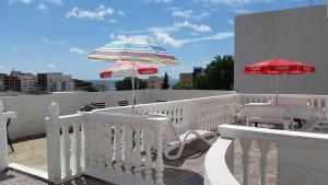a balcony with an umbrella and some chairs at Guesthouse Ada in Bar