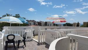 a balcony with two umbrellas and a table and chairs at Guesthouse Ada in Bar