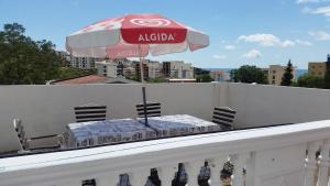 a table on a balcony with an umbrella at Guesthouse Ada in Bar