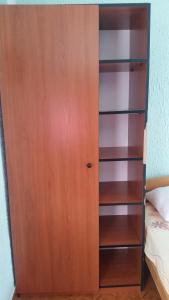 a wooden book shelf next to a bed at Guesthouse Ada in Bar
