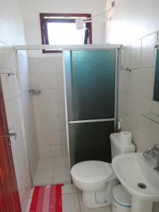 a bathroom with a shower and a toilet and a sink at Pousada Maresia in Itacaré