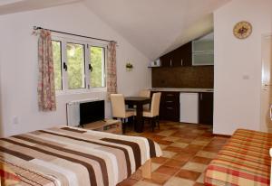 a bedroom with a bed and a kitchen with a table at Studio apartments Morinj in Donji Morinj