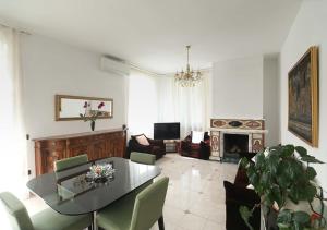 un soggiorno con tavolo, sedie e divano di Le Palme Trieste a Trieste
