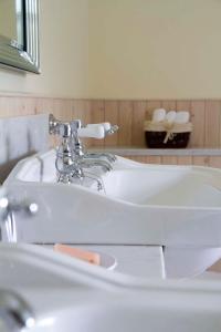 a white sink in a bathroom with a mirror at Linndhu House in Tobermory