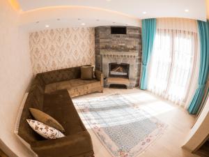 a living room with a couch and a fireplace at Elif Inan Hotel in Uzungöl