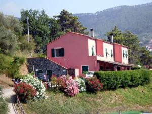 dom na zboczu wzgórza z kwiatami w obiekcie Agriturismo La Quiete w mieście Levanto