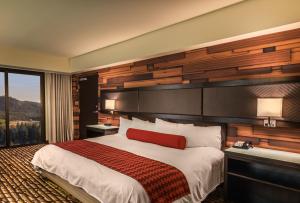 a hotel room with a large bed with a red pillow at Bally's Lake Tahoe Casino Resort in Stateline +15 photos
