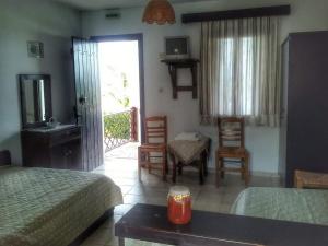 a bedroom with two beds and a table and chairs at Olga Paltsi Rooms in Paltsi Pilion