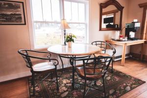 a dining room table with chairs and a table with a plant on it at Kings Landing in Homer