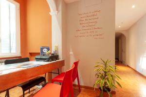 a bar with red chairs and a writing on the wall at B&B Cento Passi Dalle Mura in Lucca