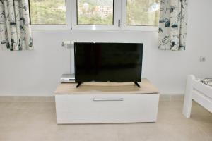 a flat screen tv sitting on top of a dresser at Studio apartments Morinj in Donji Morinj