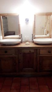 a bathroom sink with two mirrors on a wooden vanity at Ferme U San Martinu in Sisco