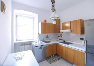 a kitchen with a sink and a refrigerator at Le Palme Trieste in Trieste +4 photos