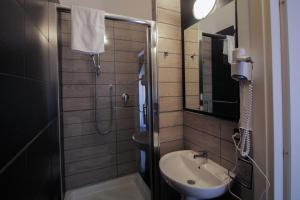 a small bathroom with a sink and a shower at La Suite Rooms & Apartments in Bologna