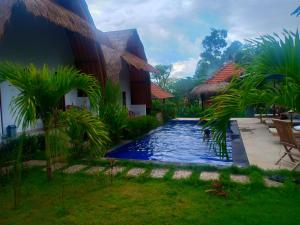 a swimming pool in front of a house at Jona Bungalow in Nusa Penida