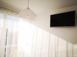 a flat screen tv hanging on a wall next to a window at Coco Lodge Paracas in Paracas