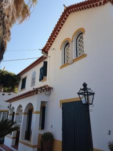 una casa blanca con una puerta negra y una luz de la calle en Casa do Cerrado, en Casal da Igreja