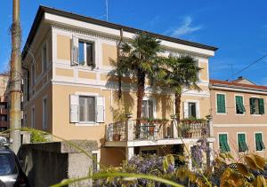 a building with palm trees and a balcony at Le Palme Trieste in Trieste