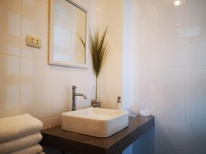 y baño con lavabo blanco y espejo. en Coco Lodge Paracas, en Paracas