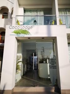 a glass entryway to a building with a sign at Coco Lodge Paracas in Paracas