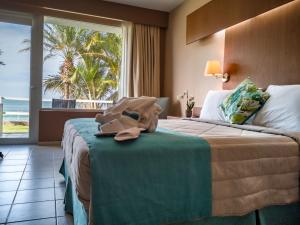 a hotel room with a bed with a view of the ocean at MantaHost Hotel in Manta