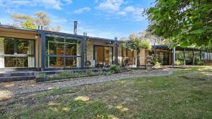 a house with large windows and a yard at Bright River Rest in Bright