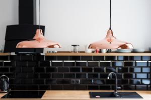 una cocina con dos luces colgantes sobre un fregadero en Apartament SWEET TIME, en Wroclaw 21 fotos más