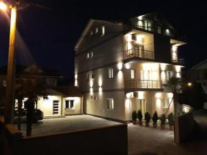 a large white building with lights on it at night at Vila & Apartments MATEA in Gevgelija