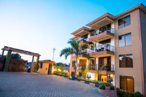 a large apartment building with a cobblestone driveway at Kampala Suburbs Apartment in Kampala